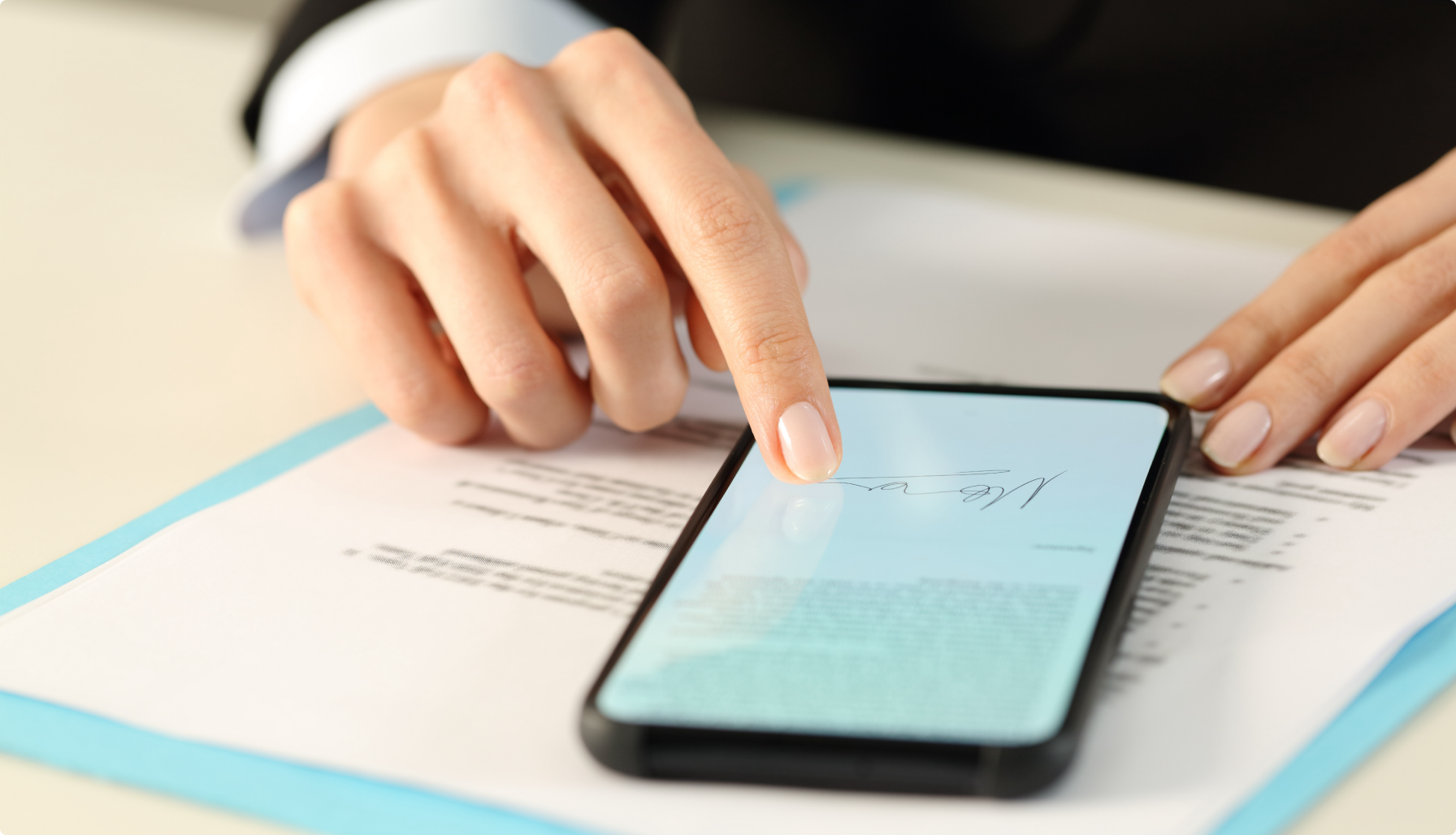 Someone signing a document on their phone